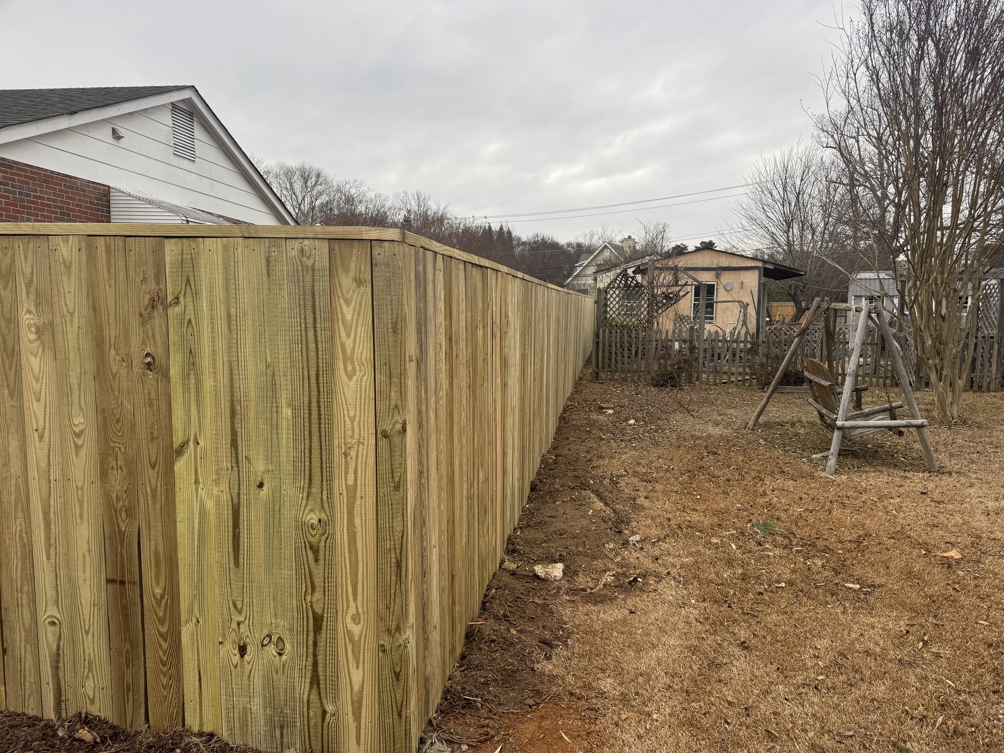 Long run of wood privacy fencing across a backyard